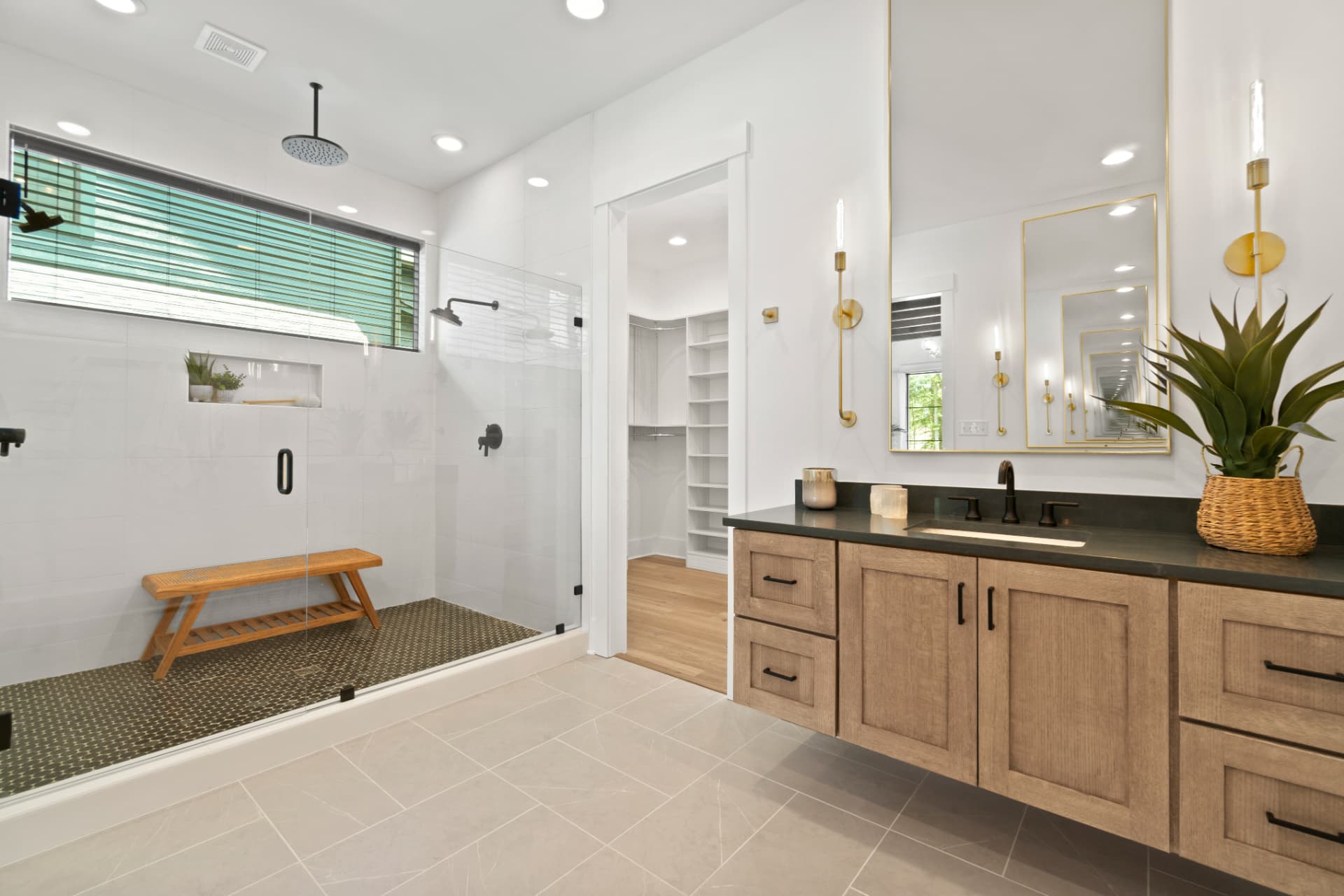 Primary bathroom with natural-wood vanity and brass fixtures
