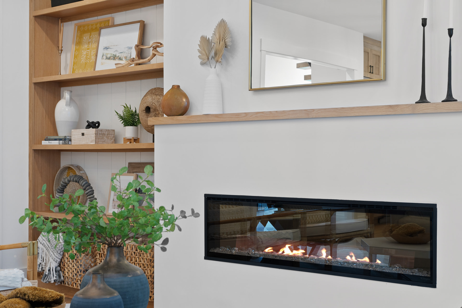Oak built-in shelving beside a linear fireplace
