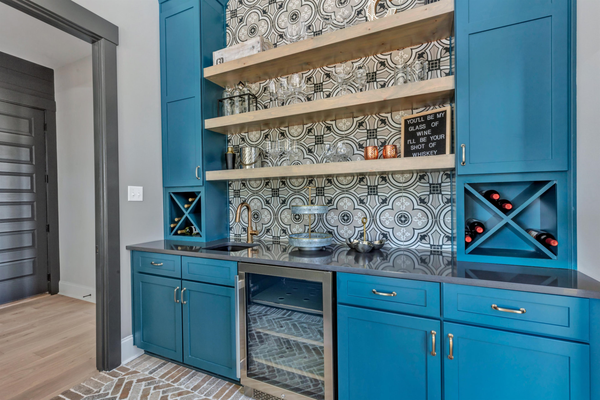 Teal shaker wet bar with wine cubbies, floating shelves and beverage fridge