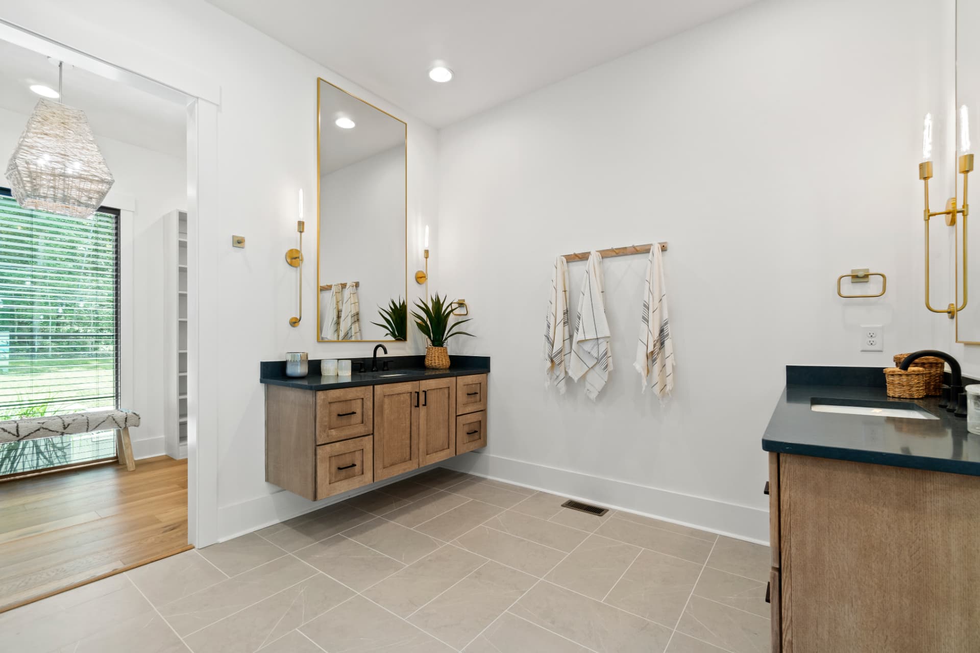 Floating wood vanities beneath brass sconces