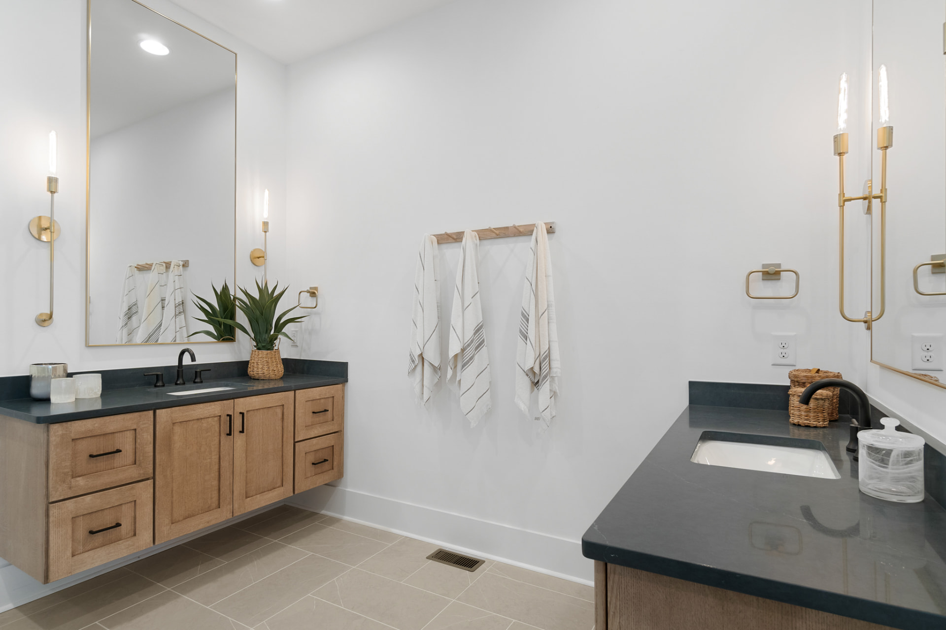 Bathroom with floating natural-wood vanities and dark countertops