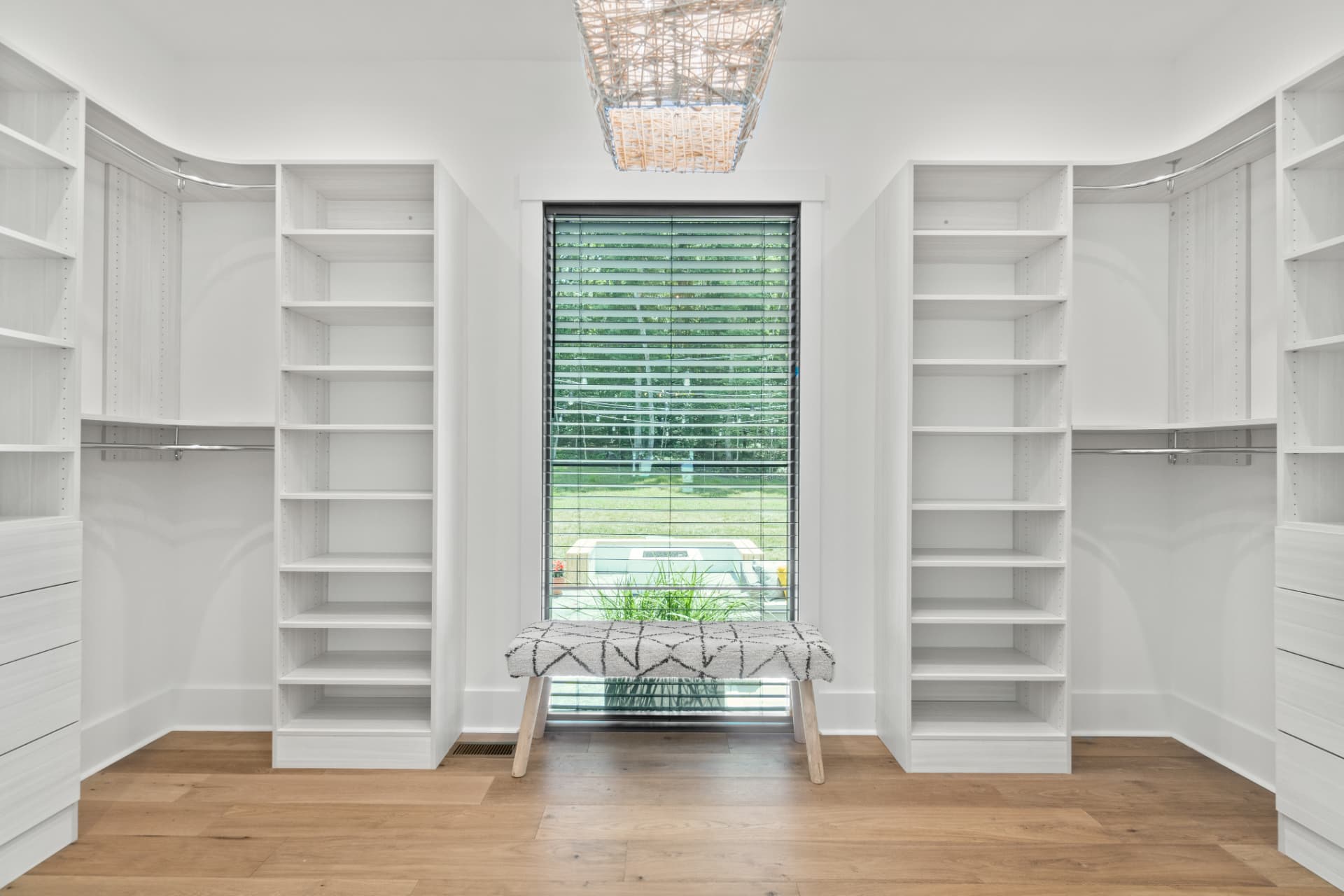 Walk-in closet with white built-in shelving and hanging storage